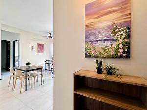 a dining room with a table and a painting on the wall at a29 seaview luxury 3BR-10PAX URBAN NETFLIX in Jelutong