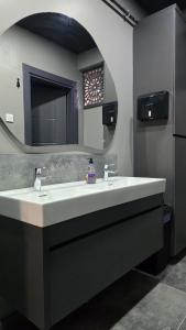 een badkamer met een wastafel en een spiegel bij YOUR HOUSE Apart Otel in Karaköprü Köyü