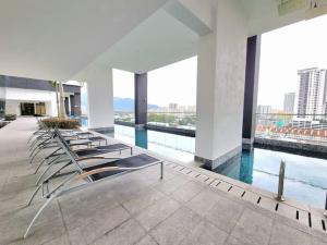 a row of chairs in a building with a pool at a29 seaview luxury 3BR-10PAX URBAN NETFLIX in Jelutong