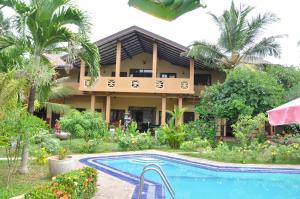 a resort with a swimming pool in front of a building at Solomon Beach Hotel in Marawila