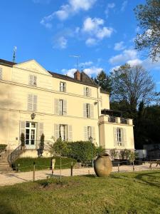 a large white house with a vase in front of it at Hôtellerie Nouvelle de Villemartin in Morigny-Champigny +40 photos