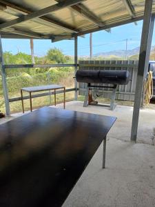 a black table and a grill in a building at Maison de campagne la foa in Méaré