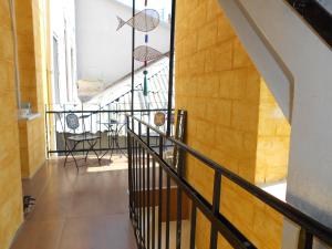 a hallway with a staircase with chairs and a table at Ergzotic Apartments & Room in Sombor
