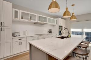a kitchen with white cabinets and a large white counter top at Main Street Retreat Chatt in Chattanooga