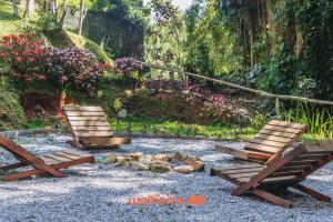 two chairs and a picnic table in a garden at Refúgio Romântico em Petrópolis com Jacuzzi in Petrópolis