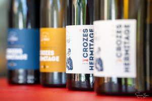 a row of bottles of wine sitting on a shelf at Le Gîte des Louis in Chanos-Curson