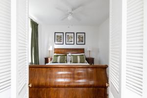 a bedroom with a wooden bed and a ceiling fan at Luxury Cornish Seaview Bungalow in Looe