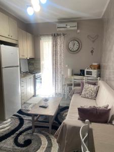 a living room with a couch and a table and a kitchen at Zoe Akrata Apartment in Paralía Akrátas