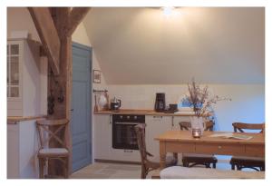 a kitchen with a table and a table and chairs at Ferienwohnung - De Deelstuuv in Worpswede