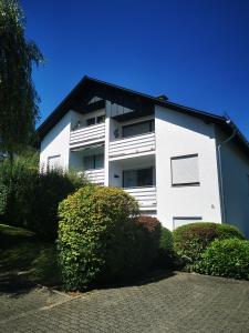 a white building with bushes in front of it at Fewo Kuhlmann in Willingen