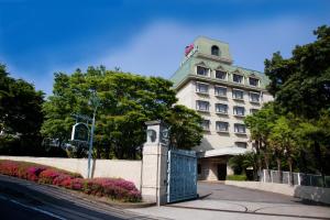 ein Gebäude mit einem Tor davor in der Unterkunft Resorpia Beppu in Beppu