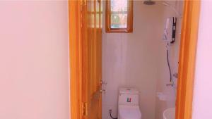 a bathroom with a toilet and a window at Evelina House in Boma la Ngombe