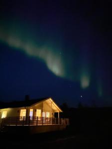 a house under the aurora in the sky at Brygghaugen, middle of Senja in Senja