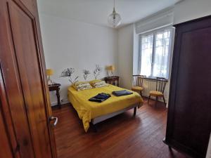 ein Schlafzimmer mit einem Bett mit einer gelben Decke in der Unterkunft Maison bretonne traditionnelle in Perros-Guirec