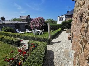einen Garten mit Stühlen und Blumen im Hof in der Unterkunft Maison bretonne traditionnelle in Perros-Guirec