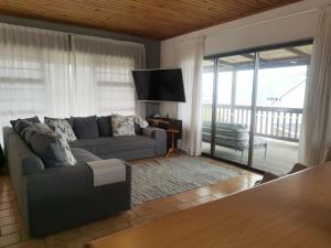 パーリー・ビーチにあるSpacious, comfortable beach houseのソファとガラスの引き戸のあるリビングルーム