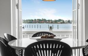 a dining room table with chairs and a view of the water at 2 Bedroom Stunning Home In Gråsten in Gråsten