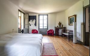 a bedroom with a bed and red chairs and a fireplace at Maison de Maître au bord du lac in Excénevex +42 photos