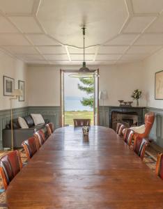 a room with a large wooden table and chairs at Maison de Maître au bord du lac in Excénevex