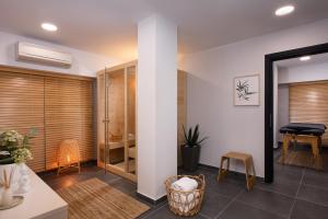 a living room with wood blinds and a table and chair at Athenian Riviera Hotel& Suites in Athens