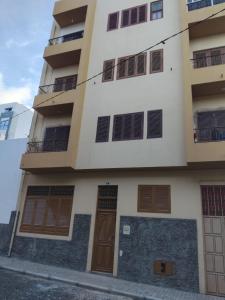 un edificio alto con puertas y ventanas marrones en Two Bedroom Condo, Mindelo, en Mindelo