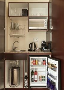 a small kitchen with an open refrigerator at Glen Avon Lodge Boutique Hotel in Cape Town