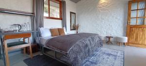 a bedroom with a bed and a table and window at Arthaat by T&C Living in Chakrāta