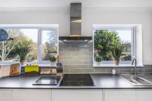 Una cocina con fregadero y dos ventanas. en 4 Bedroom Elegant House Near Peterborough City Center with Free Parking - Angus Suites by Contractor Lettings, en Peterborough 11 fotos más