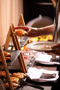 a person holding a piece of food on a table at Athenian Riviera Hotel& Suites in Athens