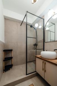 a bathroom with a sink and a glass shower at The Monarch Residential 10 in Suceava +49 photos