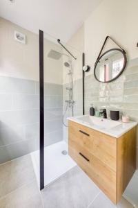 a bathroom with a sink and a shower with a mirror at le cosy pantin in Pantin
