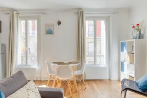 a white living room with a table and chairs at le cosy pantin in Pantin +12 photos