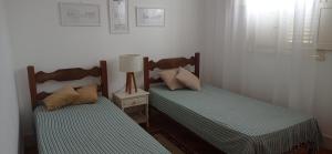 two beds sitting next to each other in a bedroom at Apartamento no Centro Histórico in São João del Rei