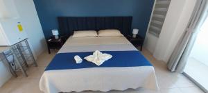 Un dormitorio con una cama con dos flores blancas. en Suite Arena, a pocos metros de la playa, en Puerto Baquerizo Moreno