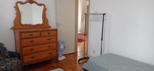 a bedroom with a dresser with a mirror on it at Apartamento no Centro Histórico in São João del Rei