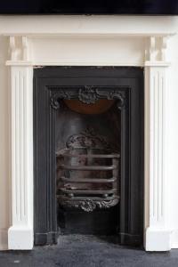 a black fireplace with a white mantel at The Cycling Cottage, Surrey Hills AONB, Dorking in Dorking