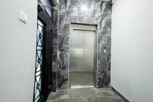 a hallway with a metal door in a stone wall at K's Place in Accra