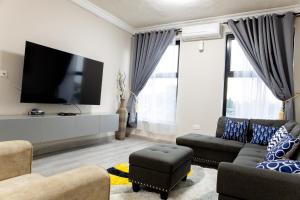 a living room with a couch and a tv at K's Place in Accra