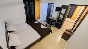 a bedroom with a bed and a desk and a mirror at Ambady Plantation Residency in Thekkady