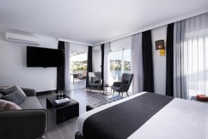 a hotel room with a bed and a living room at Athenian Riviera Hotel& Suites in Athens