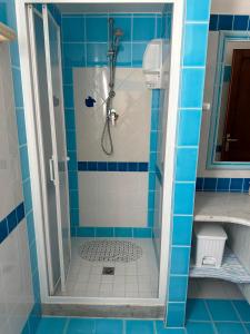 y baño con ducha de azulejos azules. en Villa Pinna, en San Teodoro 6 fotos más