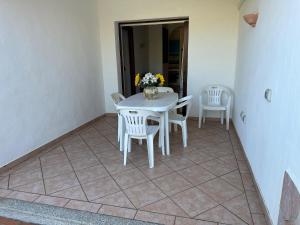 a white table and chairs on a tiled floor at Villa Pinna in San Teodoro