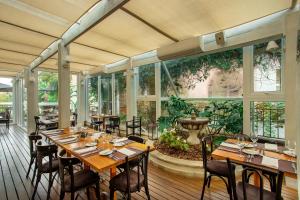 un restaurant avec des tables et des chaises en bois et une fontaine dans l'établissement 5º andar do IL Campanario Villaggio Resort, à Florianópolis