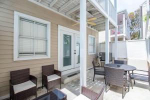a patio with chairs and a table on a porch at Sea Esta Suite - Duval Square in Key West