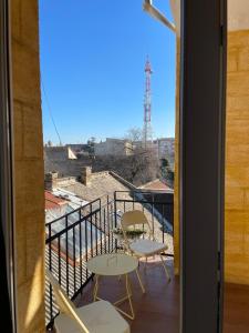 a balcony with two chairs and a view at Ergzotic Apartments & Room in Sombor