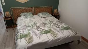 a bed with a white comforter with plants on it at F2 plages du débarquement rénové in Grandcamp-Maisy