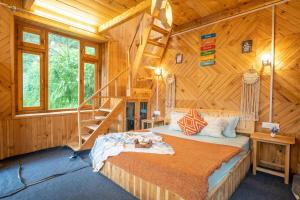 a bedroom with a bed in a wooden cabin at Enchanting Cottage With Valley View By Bastiat Stays in Mandi +18 photos