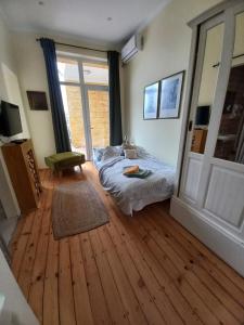 a bedroom with a bed and a large window at Ergzotic Apartments & Room in Sombor