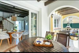 a living room with a wooden table and chairs at Ca' na Cocca - Chalet con piscina privata in Cala en Bosc