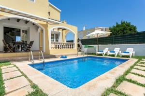 a swimming pool in the backyard of a house at Ca' na Cocca - Chalet con piscina privata in Cala en Bosc